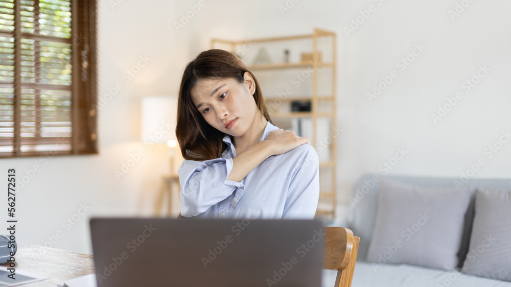 Asian woman sore muscles and neck after sitting at work or homework for