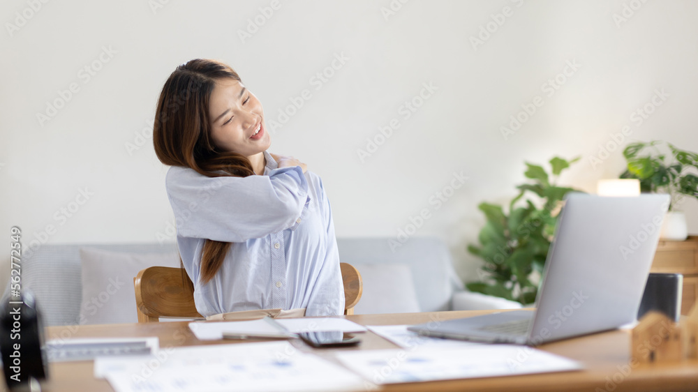 Asian woman sore muscles and neck after sitting at work or homework for a long time, Suffering from muscle aches and tendon pressure, Massage your shoulders to relax your muscles, Work from home. Asian woman sore muscles and neck after sitting at work or homework for a long time, Suffering from muscle aches and tendon pressure, Massage your shoulders to relax your muscles, Work from home.