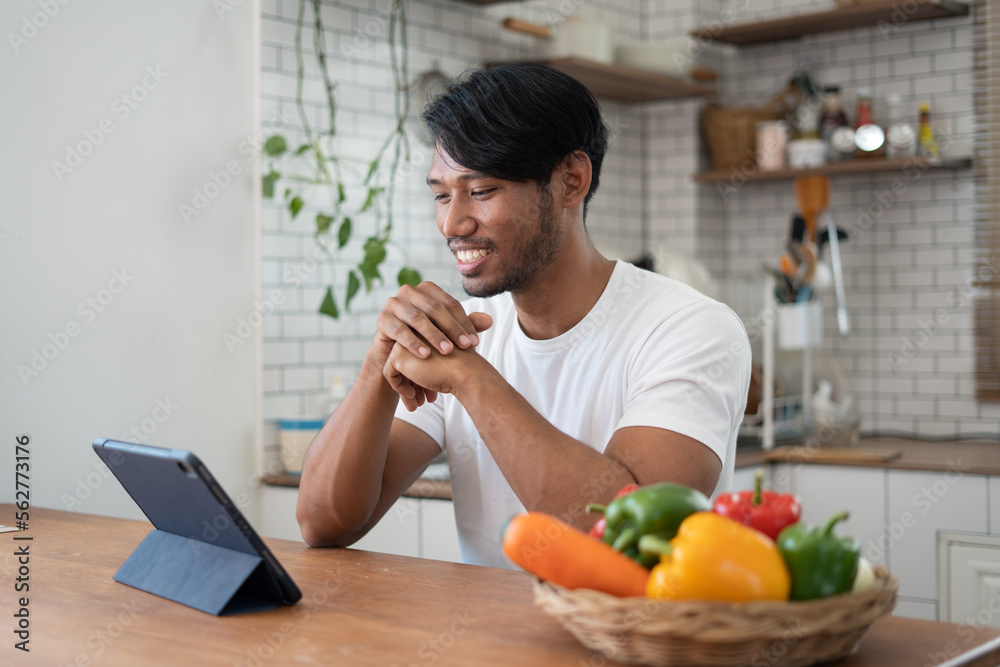Handsome asian man cooking at home preparing salad in kitchen. Handsome asian man cooking at home preparing salad in kitchen.