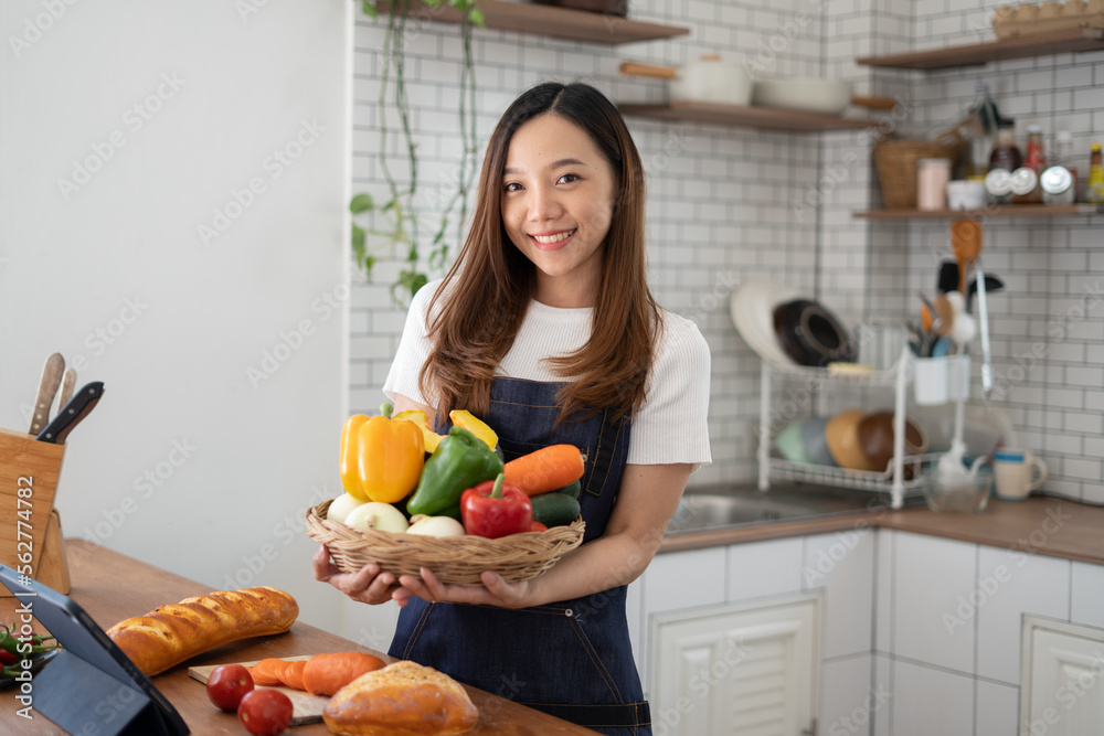 Young Asian teenage female prepare vegetable and cocking food at kitchen at home.