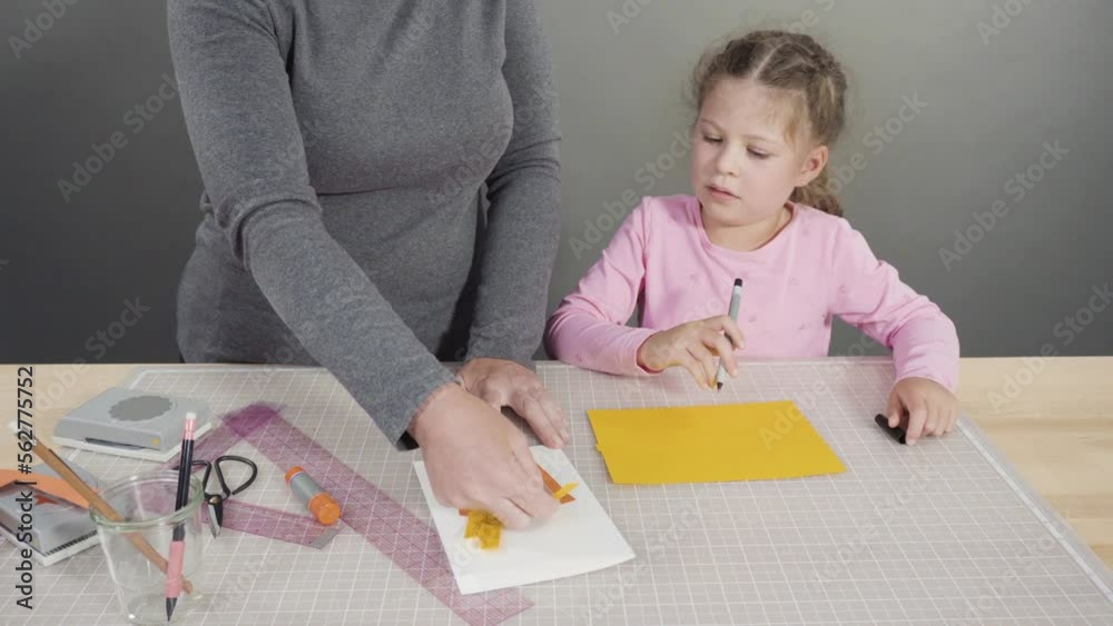 Little girl making a handmade Father's Day card from construction paper. Little girl making a handmade Father's Day card from construction paper.