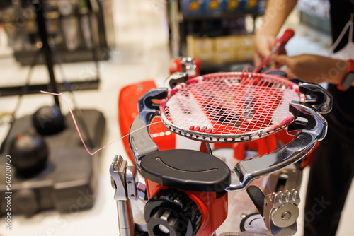 weaving badminton racket, Stringing badminton racket on racquet weaving machine. repair badminton net in sport service shop. photo