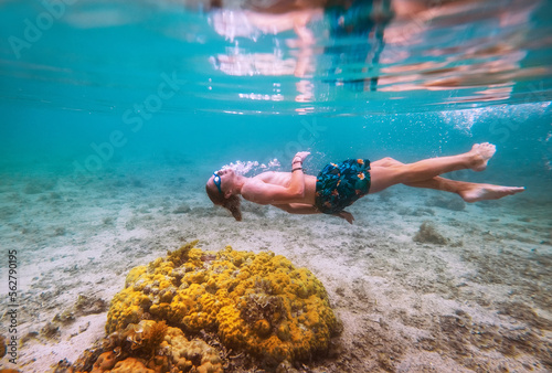 Diving teenage boy snorkeling in underwater glasses making bubbles over the coral reefs underwater photo in the clean turquoise lagoon on Le Morne beach on Mauritius island. Exotic traveling concept.