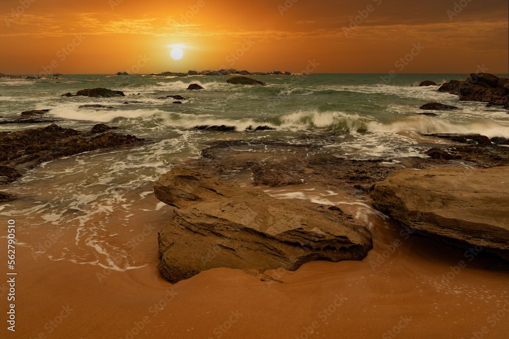 beautiful sunset over the indian ocean with rocks in the foreground sri lanka