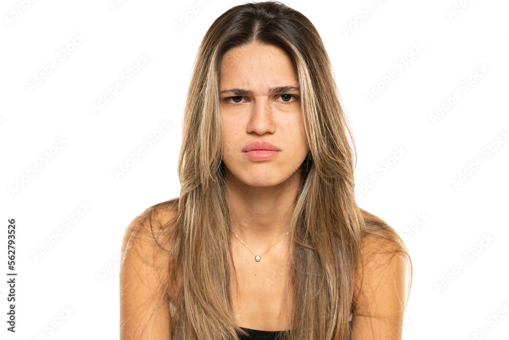 beautiful young angry women with long balayage painted hair and no makeup on a white background. beautiful young angry women with long balayage painted hair and no makeup on a white background.