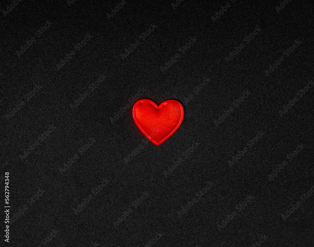 Red heart on a black background of fabric Red heart on a black background of fabric