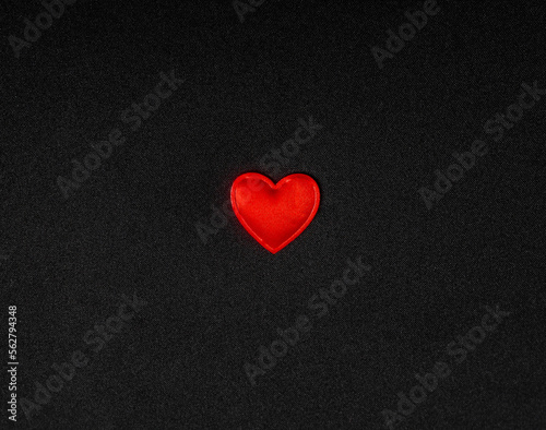Red heart on a black background of fabric
