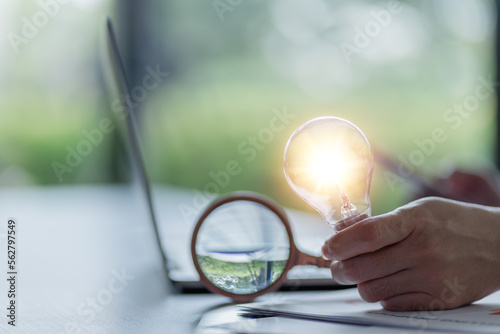 Magnifying glass with light bulb on creativity concept. new idea concept. Glowing light bulb with magnifying glass, searching creative idea, tips and tricks