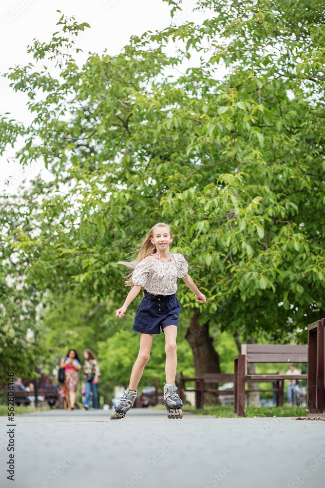 Teenager girl quickly roller skates in skate park. Active lifestyle, hobby and childhood concept Teenager girl quickly roller skates in skate park. Active lifestyle, hobby and childhood concept