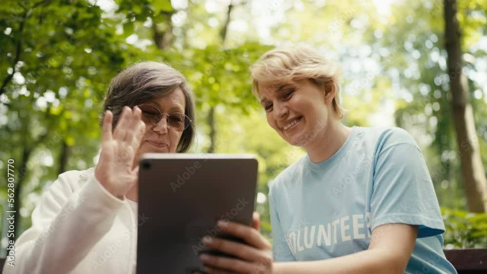 Closeup of senior woman having video call using tablet with volunteer's help Closeup of senior woman having video call using tablet with volunteer's help