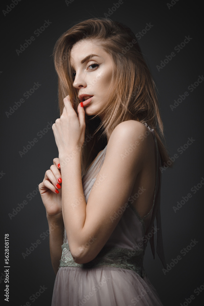 Portrait of a young attractive girl in an evening dress on a dark background. Portrait of a young attractive girl in an evening dress on a dark background.