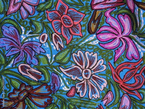 Mexican traditional embroidery in blue, pink and green on turquoise background. Flowers and leaves