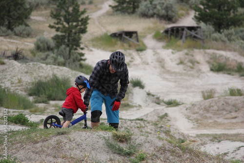 Father teaching son to ride in bike park