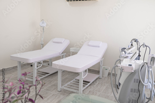 White and comfortable SPA bed standing in the middle of professional  clean and hygienic room for facial and body treatments.Modern ways of relaxation and skin care