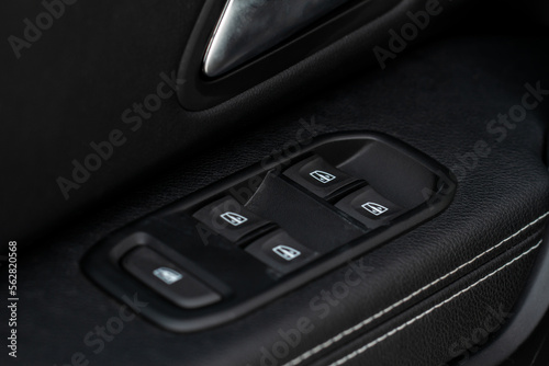 Window control buttons in modern car. Car window control panel. Modern car window switch. Door handle with power window control.
