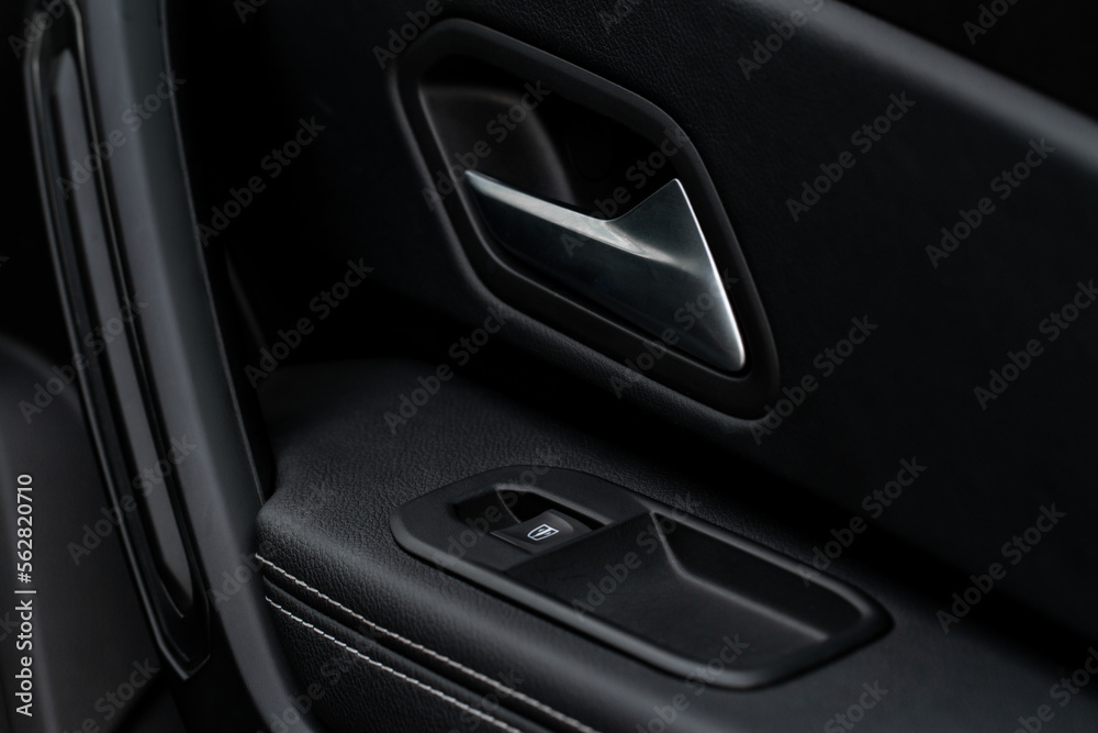 Car door handle closeup view. Car interior door panel. Modern car door panel close-up view.