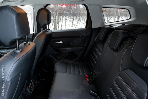 Modern car interior. Clean rear seats with the belts. Three rear seats in the row. Leather light back passenger seats.