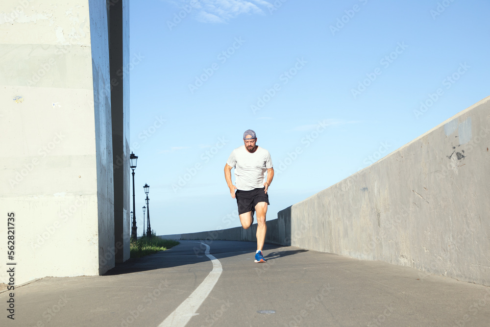 man running through the city on a sunny morning