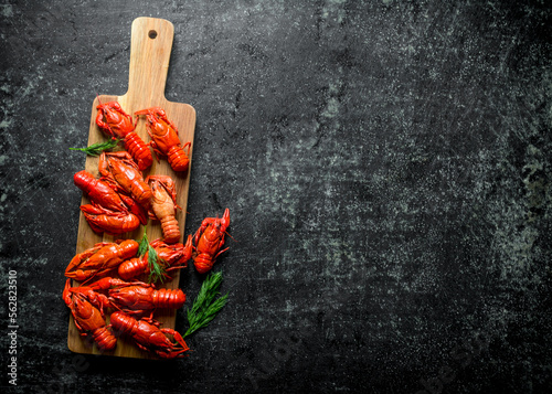 Boiled crayfish on a wooden cutting Board with dill.