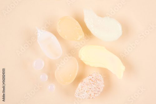 Set of cream, scrub and gel smudges - many cosmetic products smears over pastel background. Skincare and beauty products texture