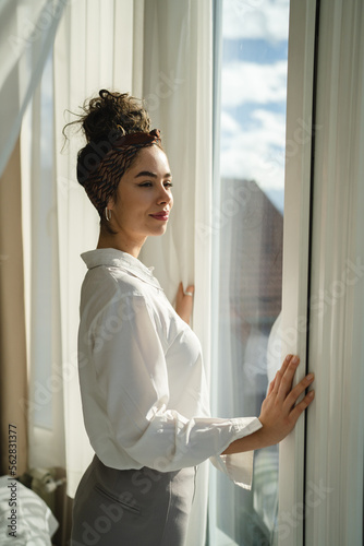 Free Download One woman beautiful caucasian stand by the window at home or hotel - GFXLoad