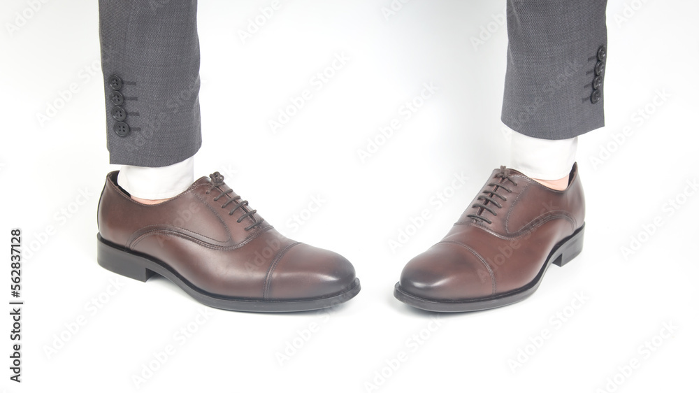 Classic brown leather shoes worn on the hands on a white background