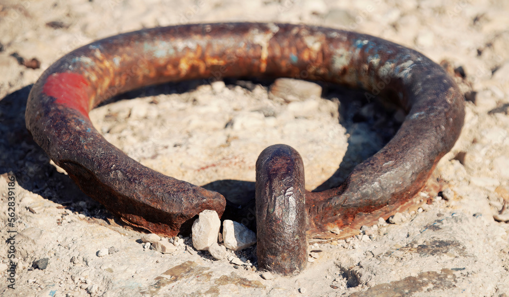 An old rusty cast iron ring used to anchor boats and ships to the concrete of a pier. Extreme closeup detail shot, daylight.
An old rusty cast iron ring used to anchor boats and ships to the concrete of a pier. Extreme closeup detail shot, daylight.