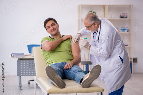 Young male patient visiting old male doctor in vaccination conce © Elnur