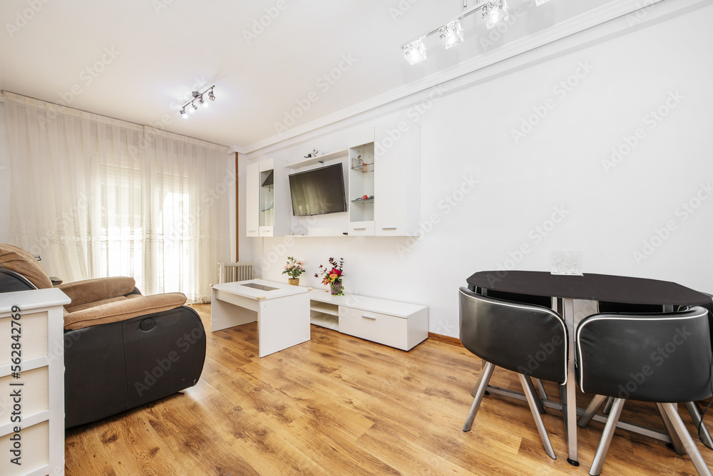 Fototapeta premium Living room of a house with a designer dining table with matching chairs, all in black and chrome metal