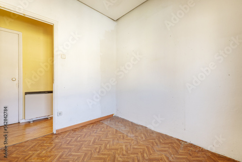Empty living room with wood-like sintasol floors and electric heat storage radiators