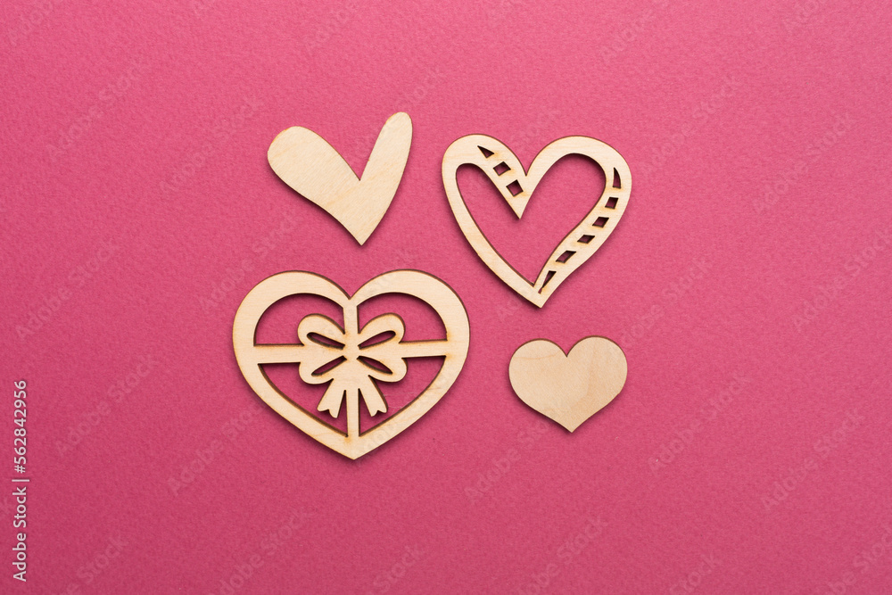 Wooden hearts on color background, top view