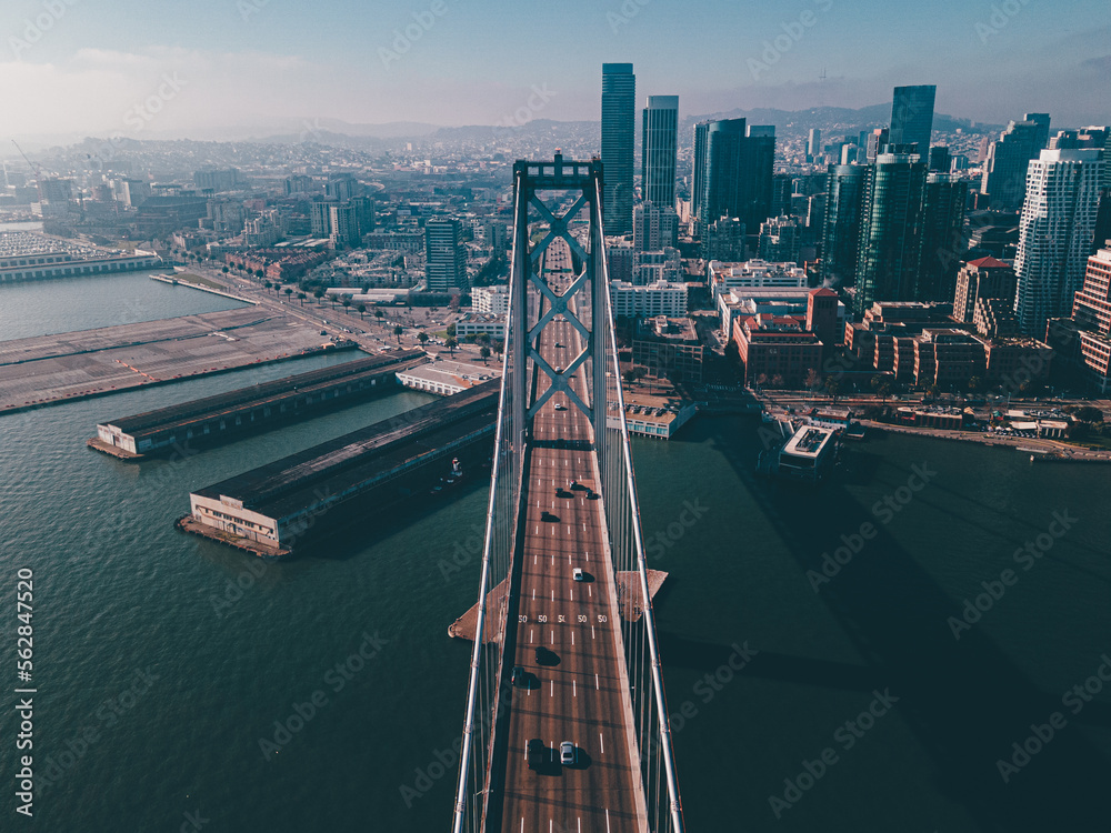 Naklejka premium Aerial photo above bridge crossing river sea drone flying through San Francisco Oakland Bay Bridge city skyline downtown