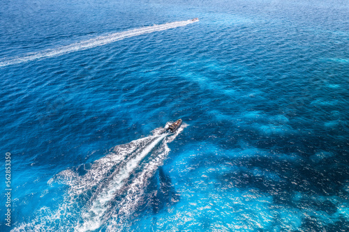 Aerial view of luxury yachts and boats on blue sea, beautiful mountain and sky with clouds at summer sunny day. Sandy beach on Tavolara island in Sardinia, Italy. Top view. Colorful seascape. Travel