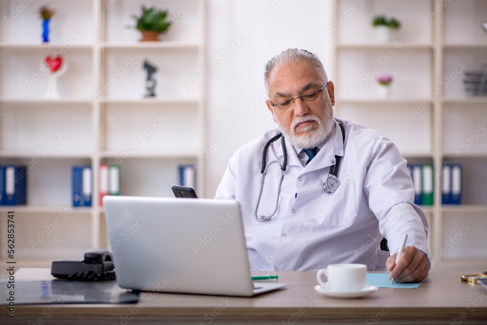 Old male doctor working in the clinic Old male doctor working in the clinic