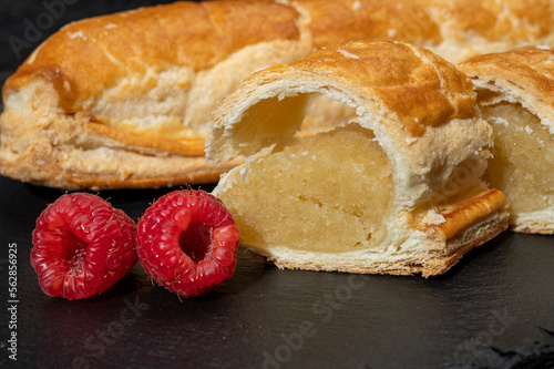 Fresh baked Dutch filled spicy cookies from puff pastry with almonds in autumn colors on dark stone photo