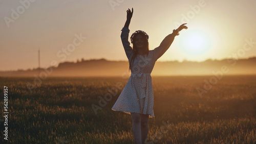 A silhouette of a young Ukrainian girl circling at sunset in the summer.