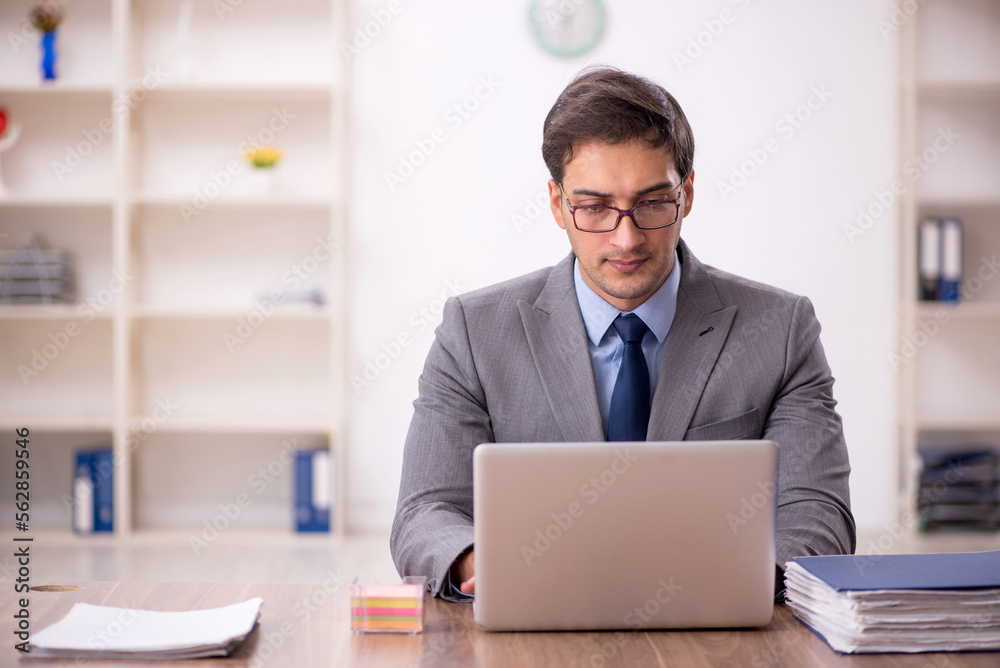 Young male employee working in the office Young male employee working in the office