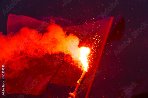 Red burning flare and polish flags
