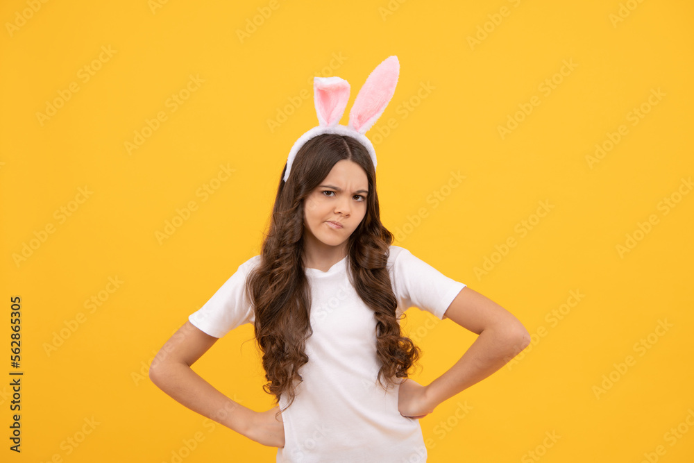 sad kid in bunny ears on yellow background, easter sad kid in bunny ears on yellow background, easter