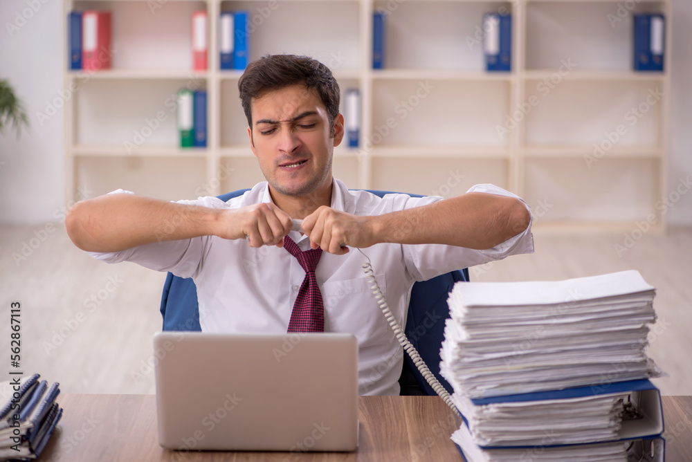 Young male employee and too much work in the office