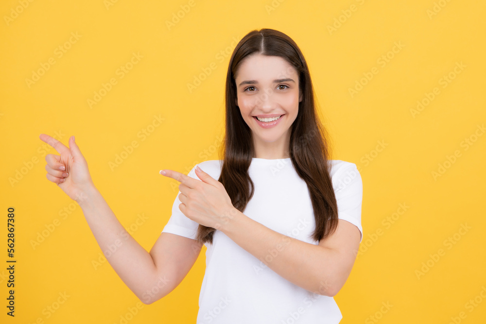 Woman point at copy space, showing copyspace pointing. Promo, girl showing advertisement content gesture, pointing with hand recommend product. Isolated yellow background. Woman point at copy space, showing copyspace pointing. Promo, girl showing advertisement content gesture, pointing with hand recommend product. Isolated yellow background.
