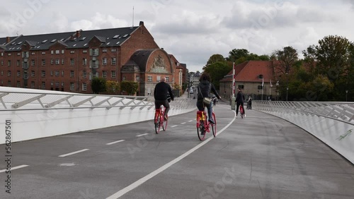 People ride bicycle and walk on pedestrian and bicycle bridge Lille Langebro,
Little Long Bridge link Langebrogade on the Christianshavn side to Christians Brygge.
