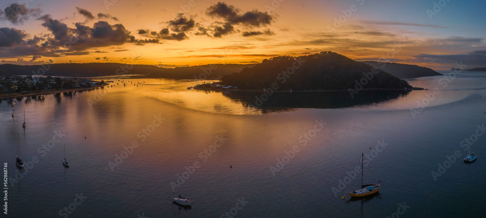 Aerial sunrise waterscape with boats and scattered clouds