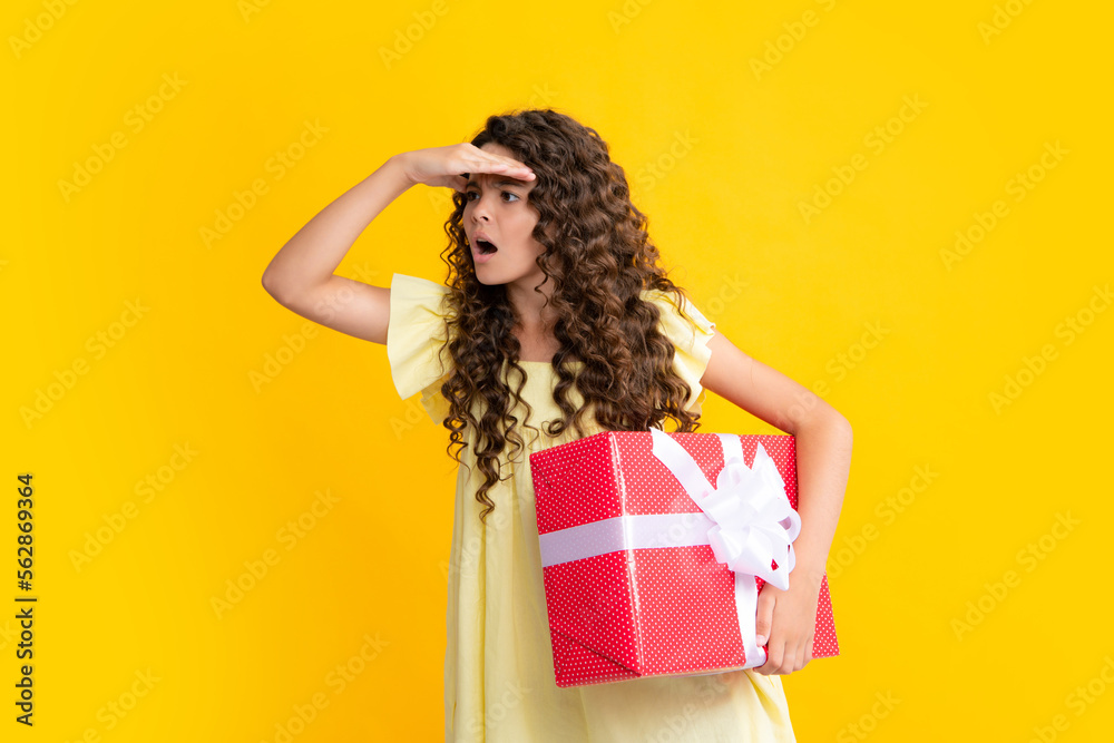 Teenager child holding gift box on yellow isolated background. Gift for kids birthday. Christmas or New Year present box. Excited teenager, glad amazed and overjoyed emotions. Teenager child holding gift box on yellow isolated background. Gift for kids birthday. Christmas or New Year present box. Excited teenager, glad amazed and overjoyed emotions.
