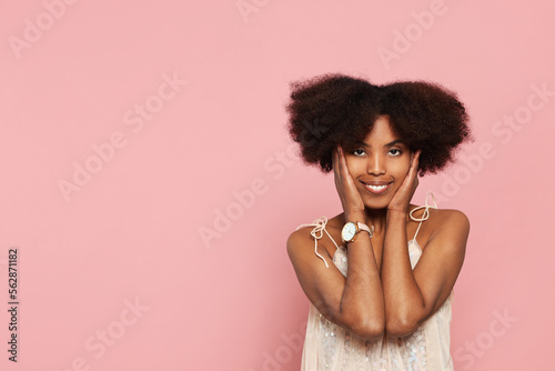 Portrait of smiling African American woman on pink background. Space for text
