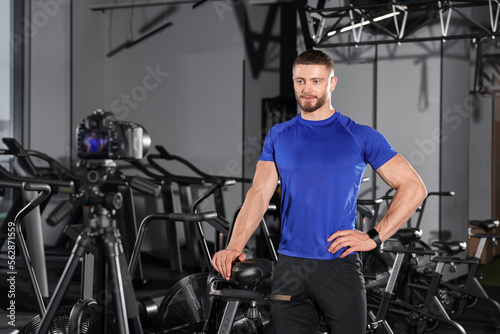 Man recording online training on camera at gym. Fitness coach