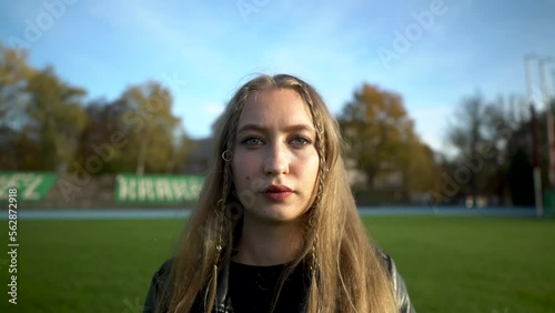 Portrait of confident slavic young woman looking to camera outside on street 