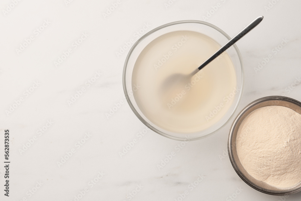 Agar-agar jelly and powder on white marble table, flat lay. Space for text Agar-agar jelly and powder on white marble table, flat lay. Space for text