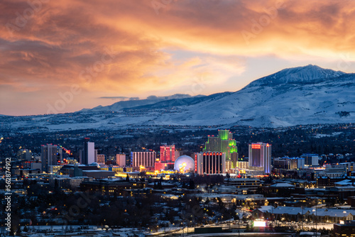 Reno, Nevada city skyline at sunset during winter with snowy mountains in the background photo