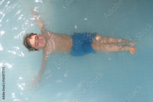 boy enjoying swimming pool in summer